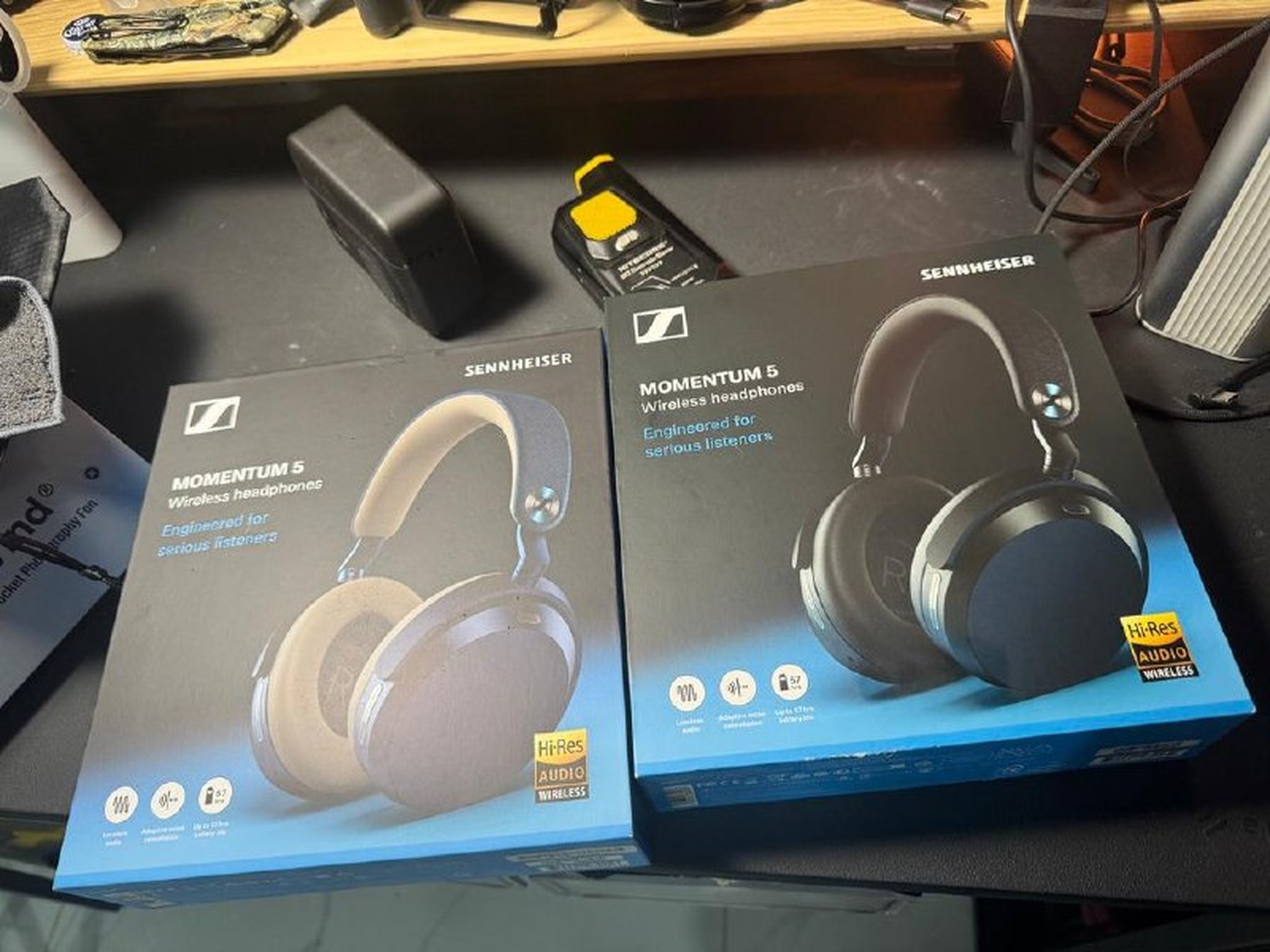 Hai hộp sản phẩm Sennheiser Momentum 5 phiên bản Black và Denim trên bàn làm việc